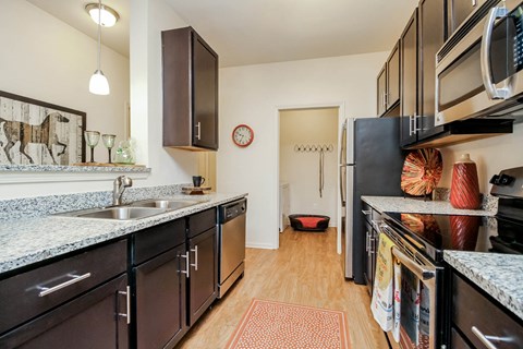 a kitchen with granite counter tops and black appliances