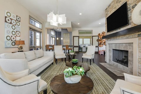 a living room with white couches and chairs and a fireplace