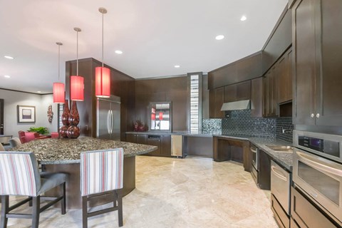 a kitchen with a large island and a table with chairs