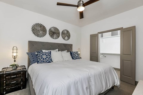 a bedroom with a white bed and a ceiling fan