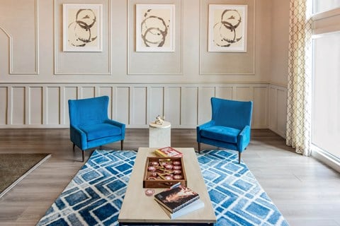 a living room with blue chairs and a coffee table