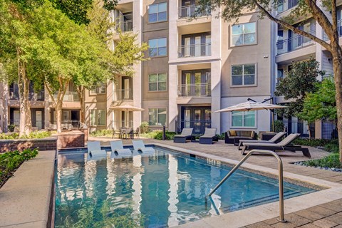 A swimming pool in front of a residential building.