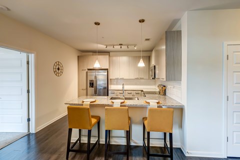 A kitchen with a table and chairs in front of it.