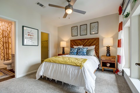 A bedroom with a white bed and a yellow blanket.