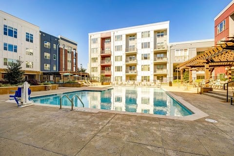A large swimming pool in front of apartment buildings.