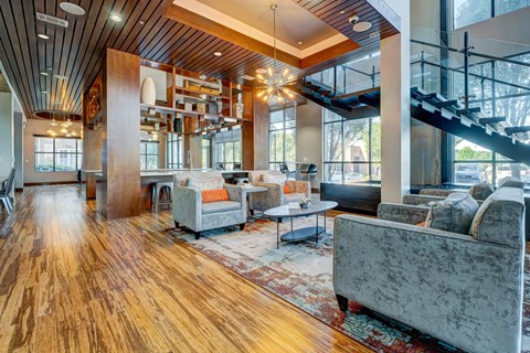 A living room with a grey couch and a wooden floor.