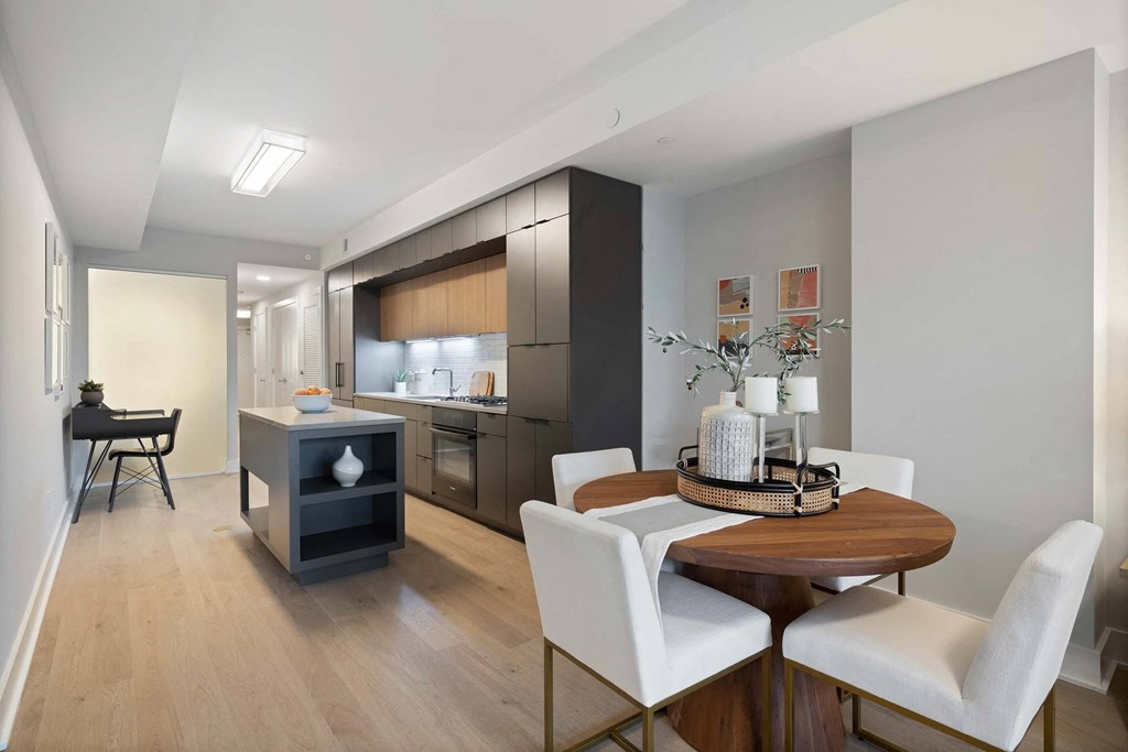 A kitchen and dining room with black cabinets and a black desk at Tribeca NOMA apartments