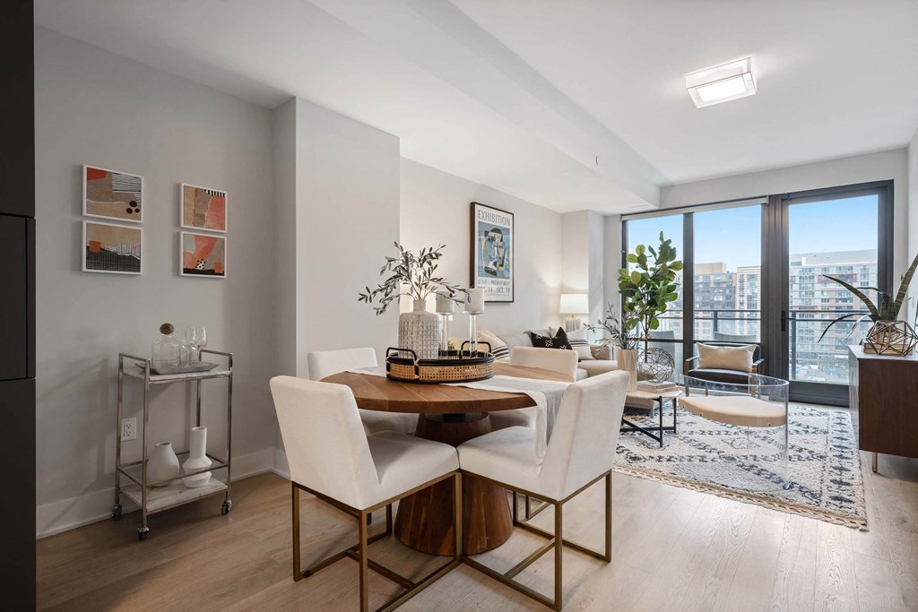 A dining room with a table and chairs and a large window at Tribeca NOMA apartments