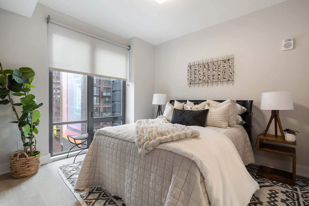 a bedroom with a large window view at Tribeca NOMA apartments
