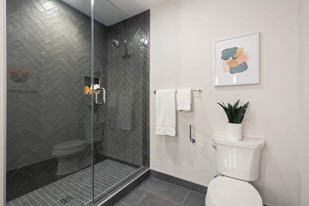 a bathroom with a toilet and a sleek shower at Tribeca NOMA apartments