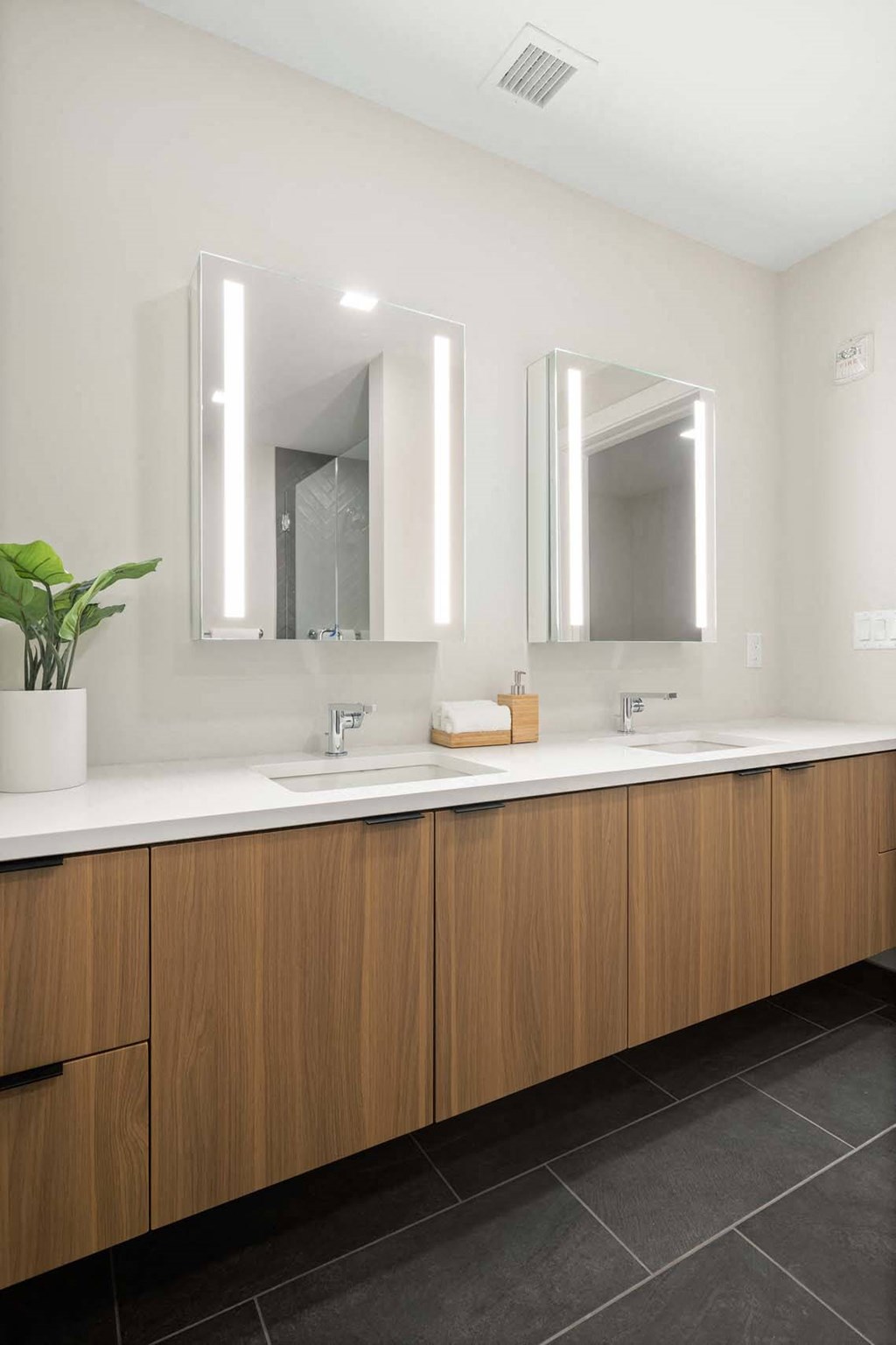 a bathroom with two sinks and two mirrors at Tribeca NOMA apartments