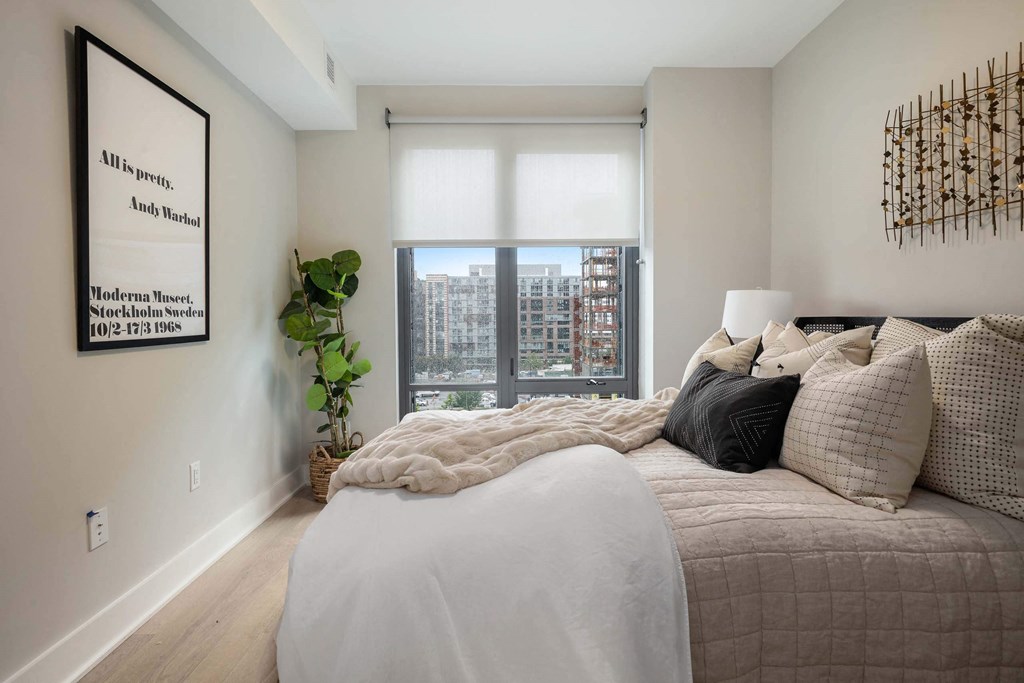 a bedroom with large windows and a view at Tribeca NOMA apartments