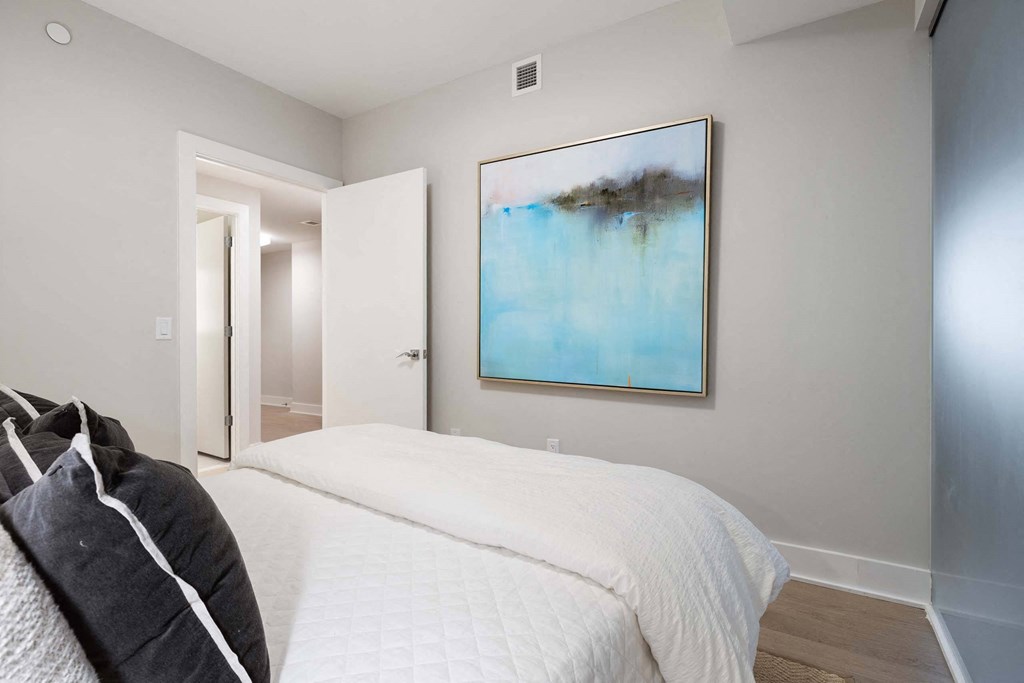 a bedroom with a large painting at Tribeca NOMA apartments
