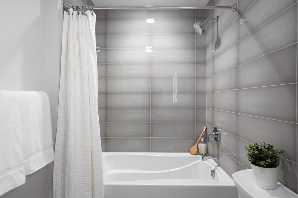 a bathroom with a bathtub shower and sink in Tribeca NOMA apartments