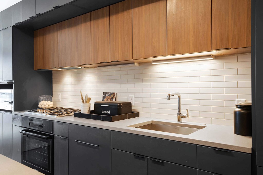 a white kitchen with wooden cabinets at Tribeca NOMA apartments