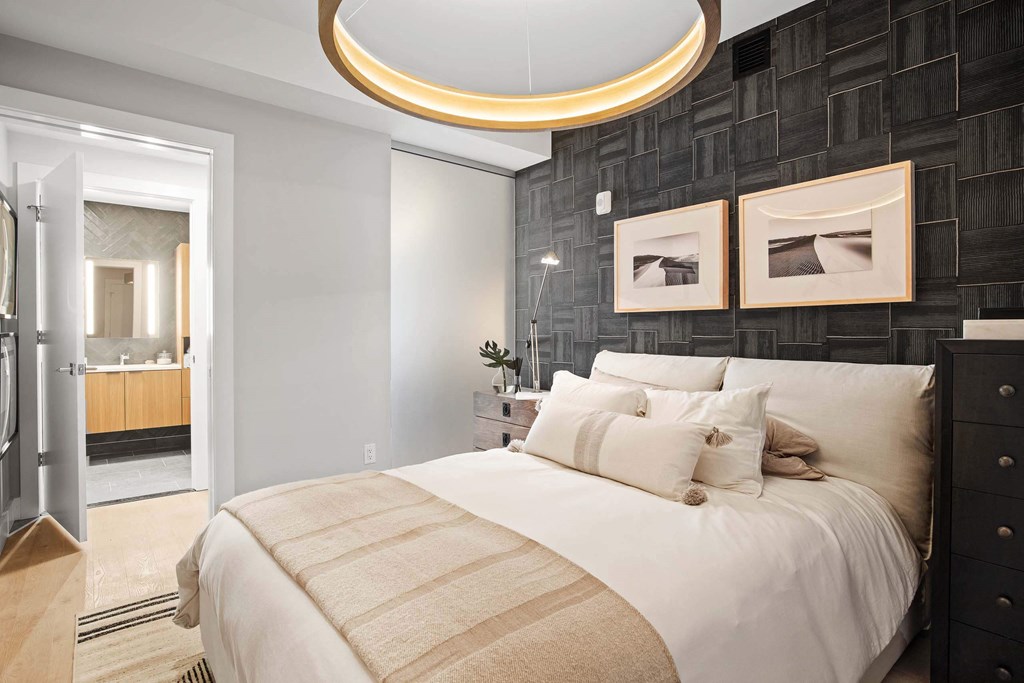a bedroom and bathroom with circular light fixture at Tribeca NOMA apartments