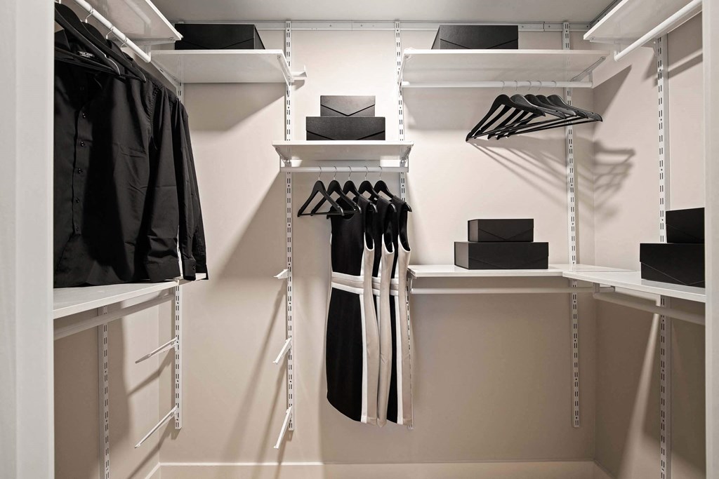 a walk in closet with white walls and white shelves at Tribeca NOMA apartments