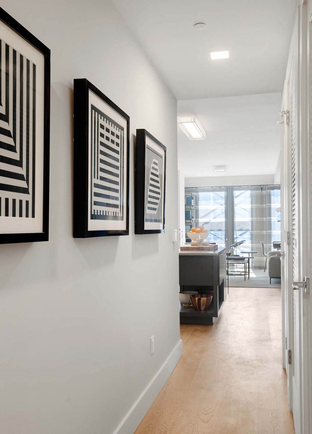 a hallway with art on the wall and a door to a living room at Tribeca NOMA apartments