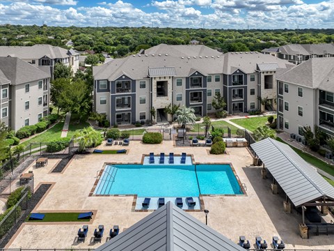 A large swimming pool is surrounded by apartment buildings.
