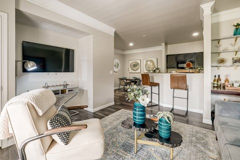 A living room with a white chair and a blue vase on a coffee table.