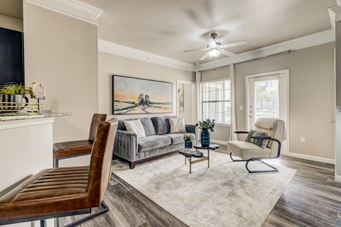 A living room with a painting of a landscape on the wall.