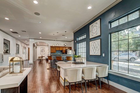 A modern dining room with a long table and chairs.