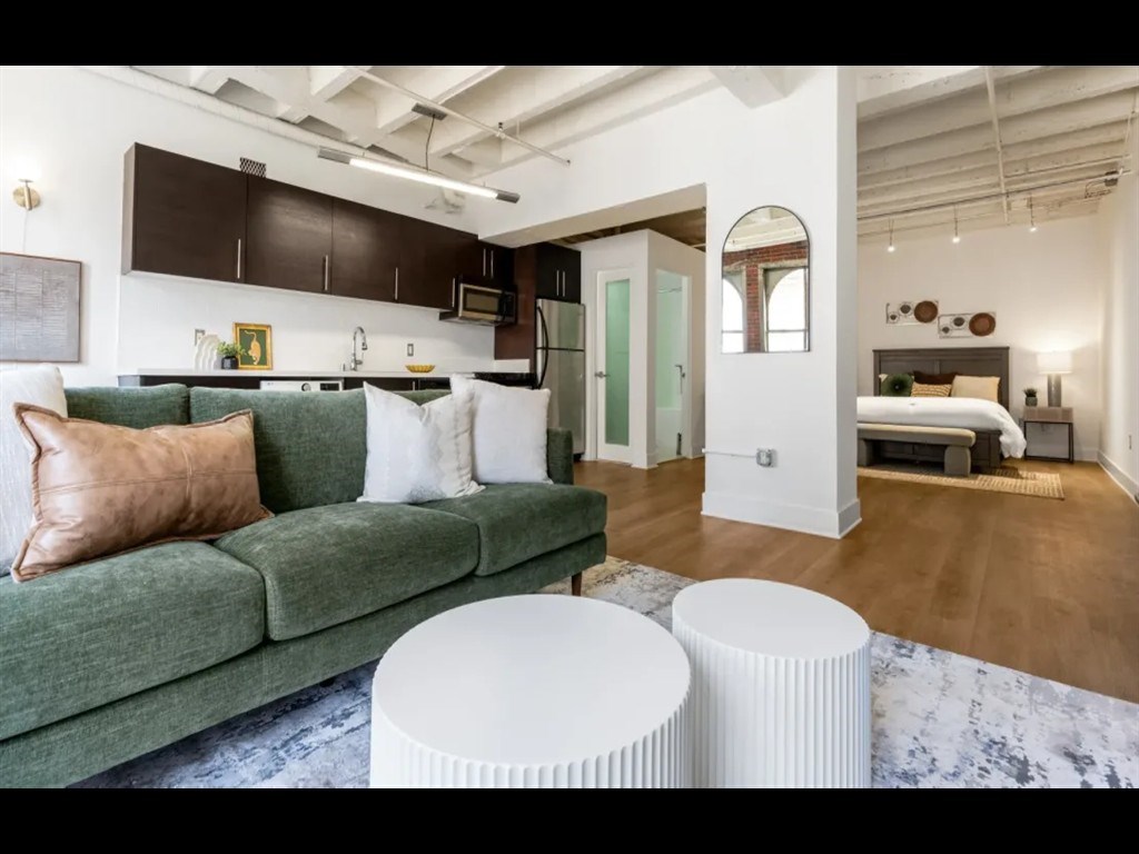 A living room with a green couch and a white coffee table.