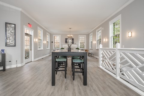 A dining room with a wooden table and chairs.