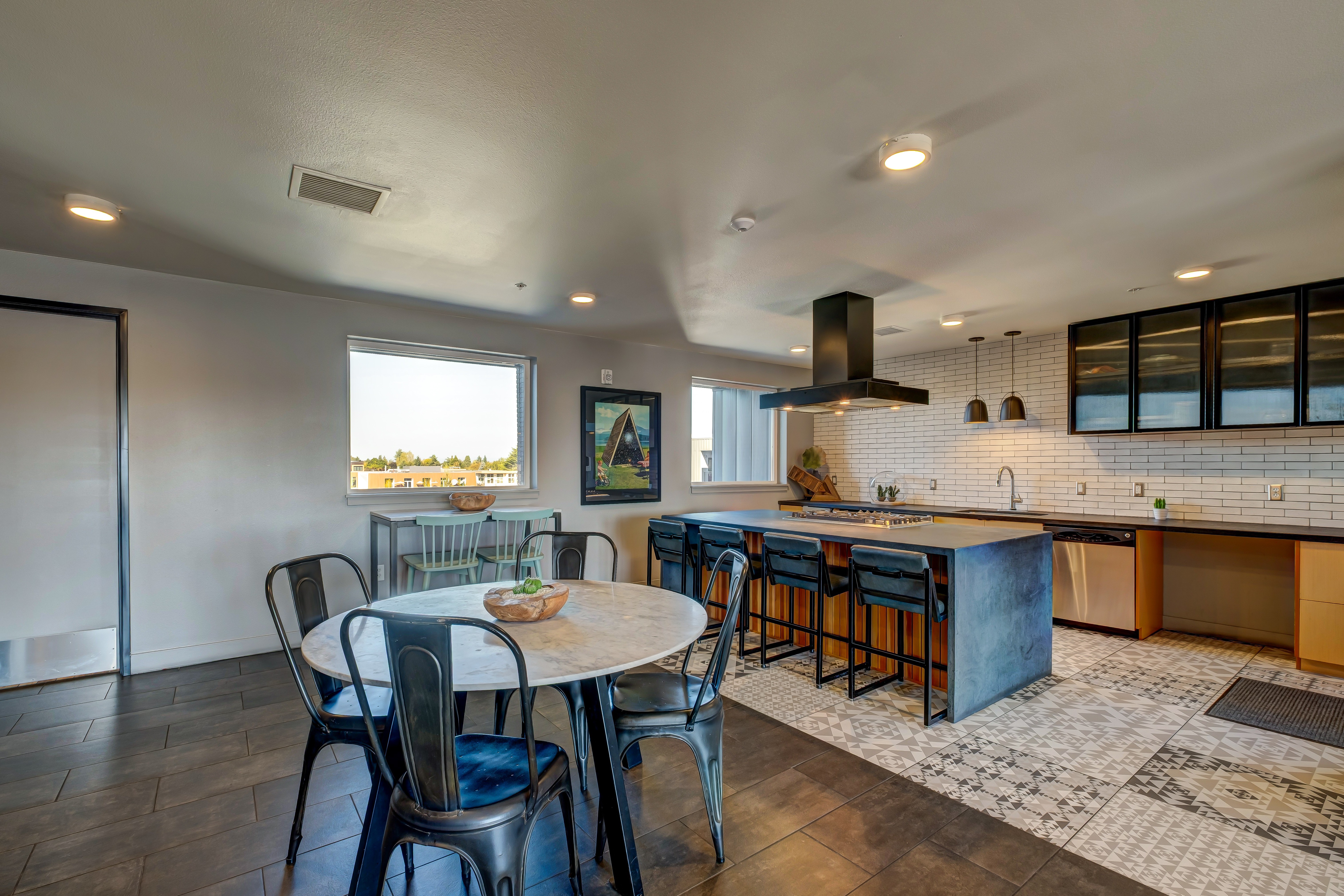 A kitchen with a table and chairs in front of a window.