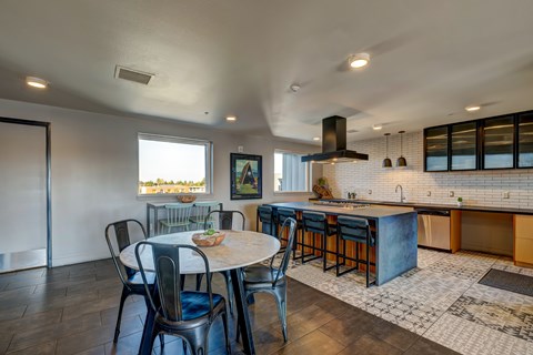 A kitchen with a table and chairs in front of a window.