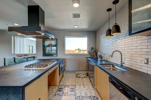 A modern kitchen with a black stove top oven and a black range hood.