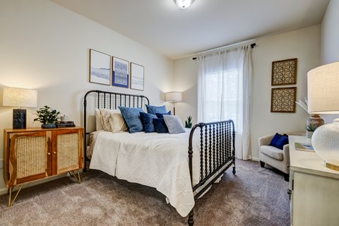 A bedroom with a white bed and a wooden cabinet.