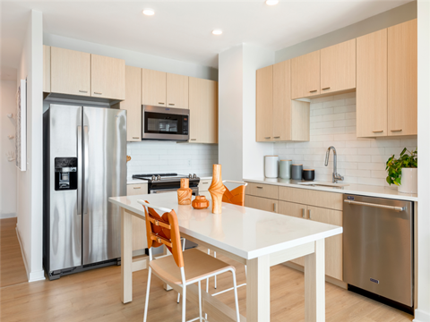a kitchen with a white table and chairs and a stainless steel refrigerator