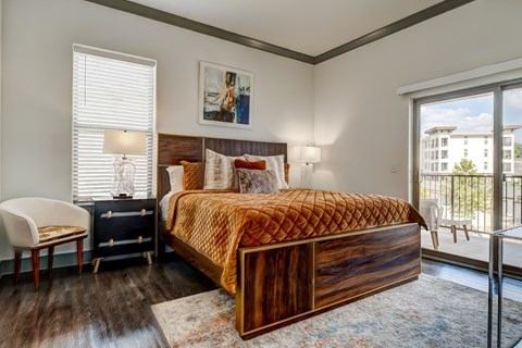 A bedroom with a large bed and a chair.