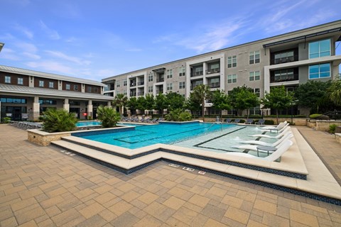 A large swimming pool in front of a building.