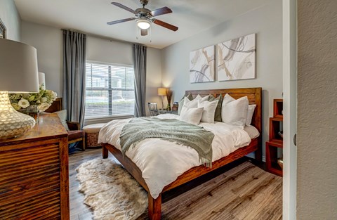 A bedroom with a large bed and a ceiling fan.