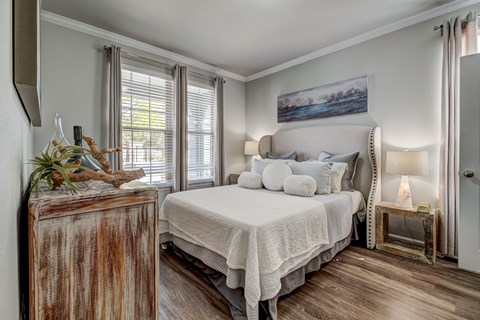 A bedroom with a large bed and a wooden chest.