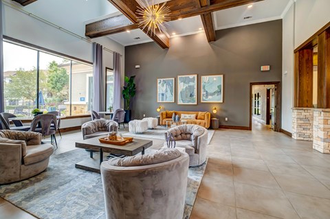 A living room with a large grey sofa and a wooden ceiling.