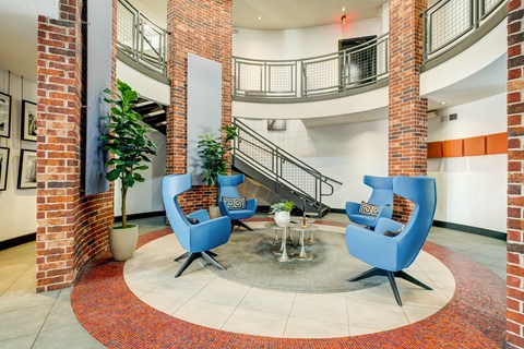 A large open space with a staircase and two blue chairs.