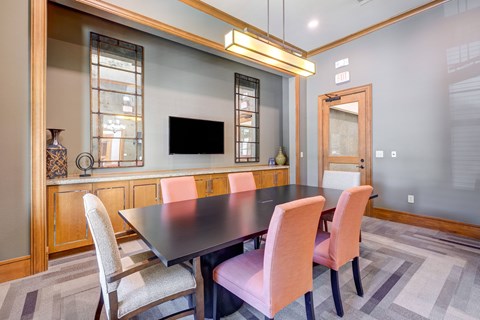 A modern dining room with a dark table and chairs.