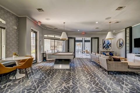 A living room with a pool table and a couch.