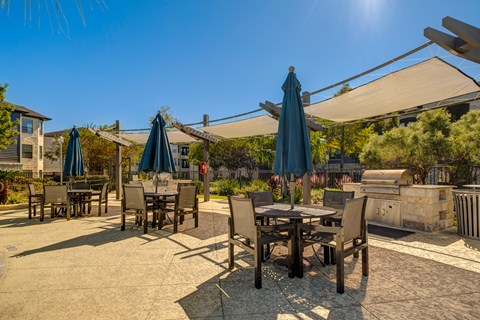 A sunny day at an outdoor dining area with tables and chairs.
