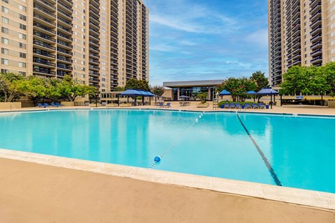 A large swimming pool in front of apartment buildings.