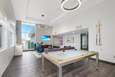 A pool table in a room with a TV and a chair.