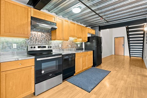 A kitchen with wooden cabinets and a black refrigerator.
