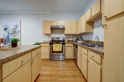 A kitchen with wooden cabinets and a granite countertop.