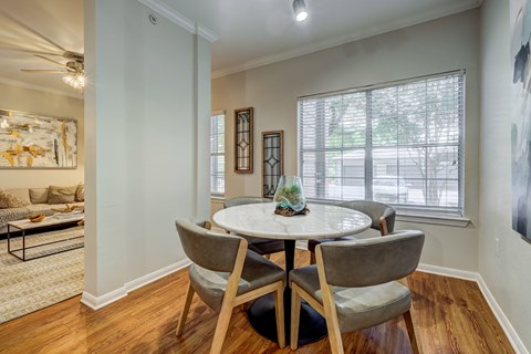 A dining room with a round table and chairs.