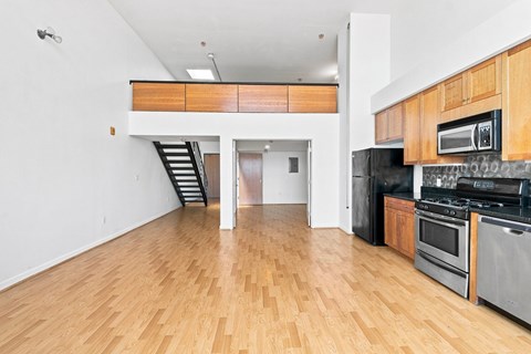 A kitchen with wooden floors and stainless steel appliances.