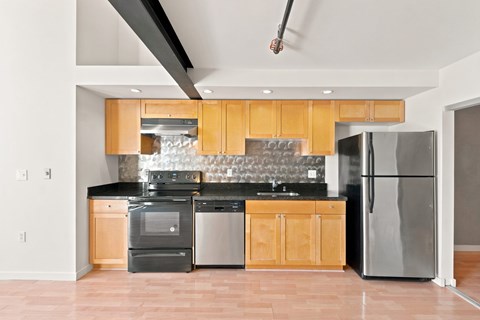 A modern kitchen with wooden cabinets and stainless steel appliances.