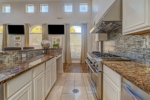 A kitchen with granite countertops and a tile backsplash.